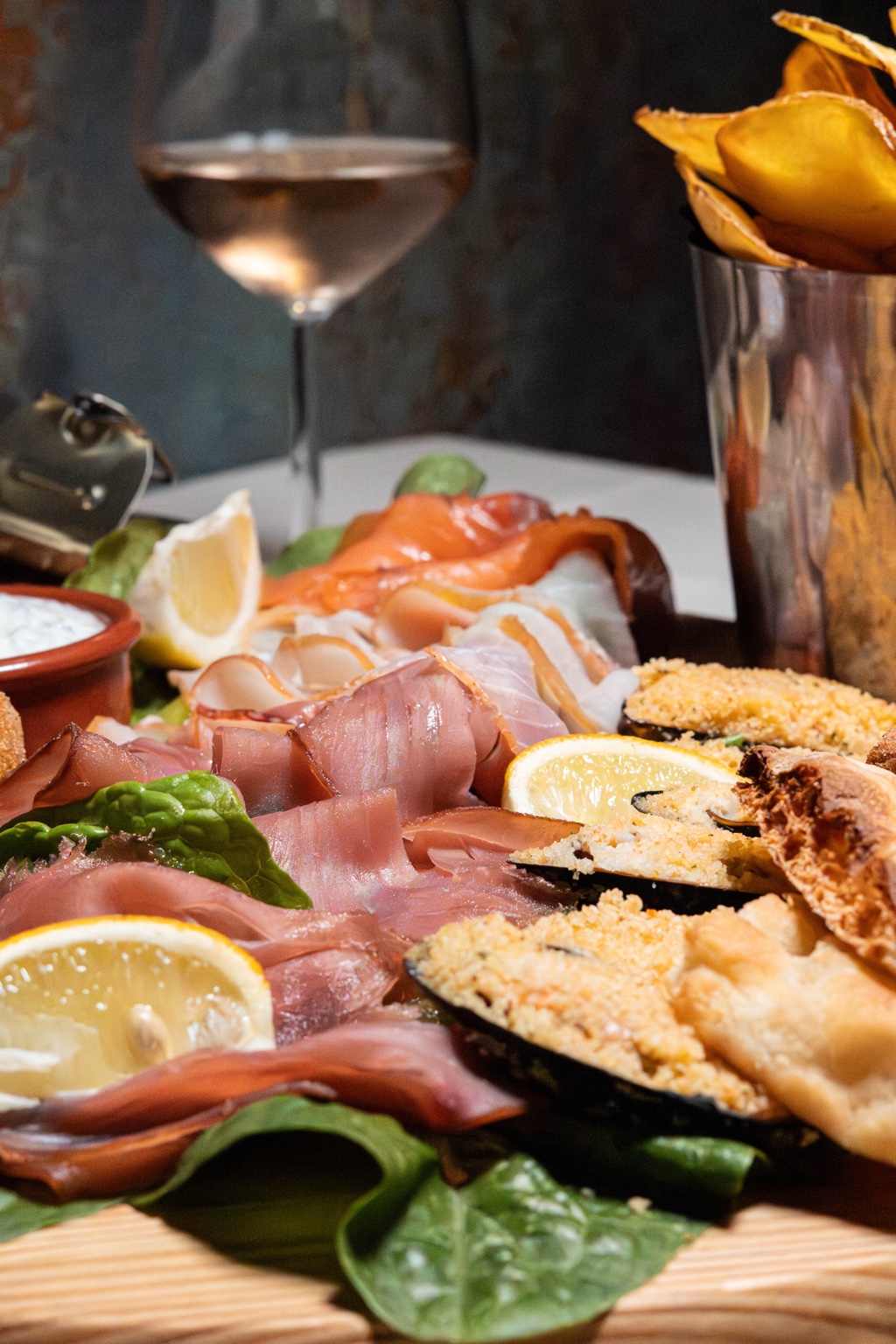 Selezione di antipasti e calice di vino durante uno shooting gastronomico
